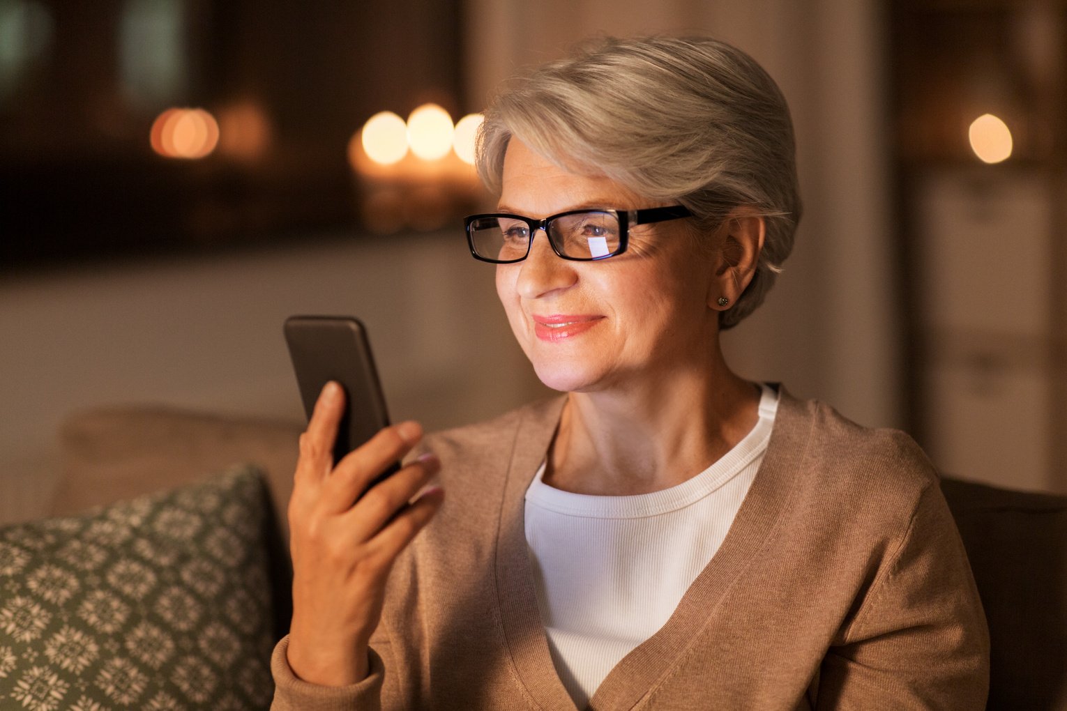 Happy Senior Woman with Smartphone at Home